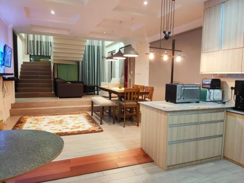 Al Hidayah Suite في بندر سيري بيغاوان: مطبخ وغرفة معيشة مع طاولة وغرفة طعام