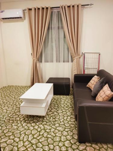 Al Hidayah Suite في بندر سيري بيغاوان: غرفة معيشة مع أريكة وطاولة قهوة