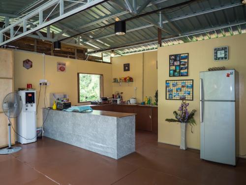 a large kitchen with a counter and a refrigerator at Timba Garden FREE TOWN AND JETTY TRANSPORT in Semporna