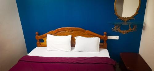 Dormitorio azul con cama con sábanas y almohadas blancas en Melba Homestay at Kodaigate, en Kodaikanal