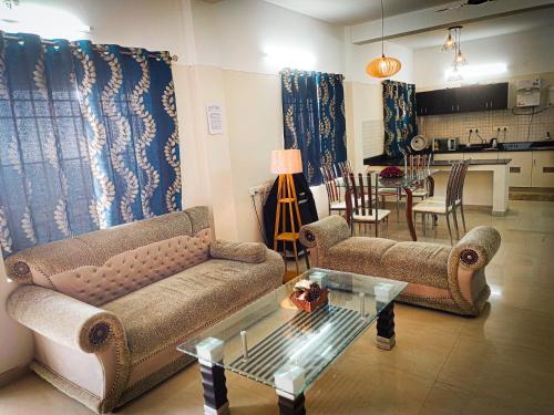 sala de estar con sofá, mesa y cocina en Melba Homestay at Kodaigate, en Kodaikanal