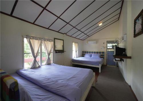 1 dormitorio con 2 camas y ventana en ภูทรายแก้วรีสอร์ทวังน้ำเขียว, en Wang Nam Khiao