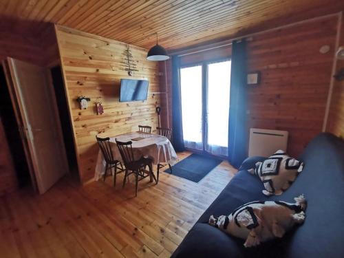 a living room with a table and a blue couch at Le refuge in Saint-Pierre-dels-Forcats