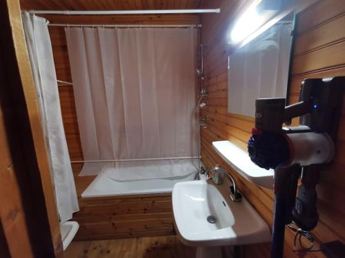 a bathroom with a sink and a shower with a shower curtain at Le refuge in Saint-Pierre-dels-Forcats