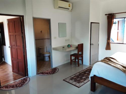 a bedroom with a bed and a desk and a door at Central Essence in Haad Chao Phao