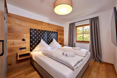 een slaapkamer met een bed met witte lakens en een raam bij Berghupferl in Garmisch-Partenkirchen