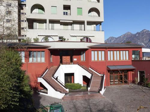 ein rotes Gebäude mit einer Treppe vor einem Gebäude in der Unterkunft Welcoming apartment in Valbrona with pool in Valbrona