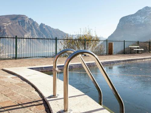uma piscina com um corrimão de metal ao lado em Welcoming apartment in Valbrona with pool em Valbrona