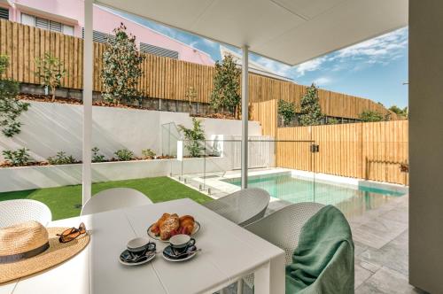 a room with a table and chairs and a pool at Essence Peregian Beach Resort - Saltbush 5 Bedroom Luxury Home with Private Pool in Peregian Beach