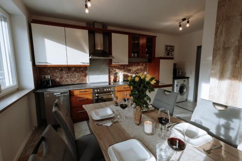 a kitchen with a wooden table with wine glasses at Stilvolles Appartement mit Blick auf das Dreiflüsse-Eck in Passau