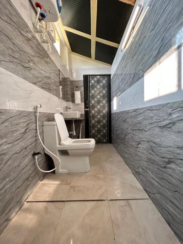 a bathroom with a toilet and a sink at Max Guest House in Agra