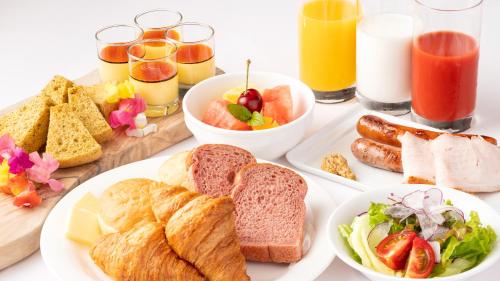 a table topped with plates of breakfast foods and drinks at EN RESORT Grandeco Hotel in Kitashiobara