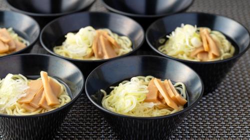 a group of small black bowls filled with noodles at EN RESORT Grandeco Hotel in Kitashiobara