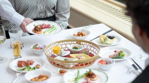 a group of people sitting at a table with plates of food at EN RESORT Grandeco Hotel in Kitashiobara