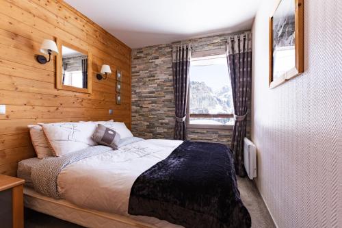 a bedroom with a bed and a brick wall at Luxury Chalet with sauna by Avoriaz Chalets in Avoriaz