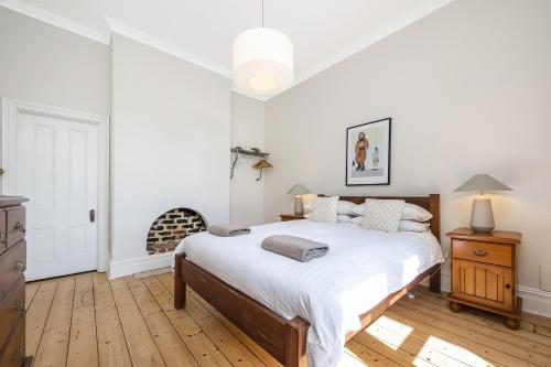 Un dormitorio blanco con una cama y una chimenea. en Apartment Faro, en Fremantle