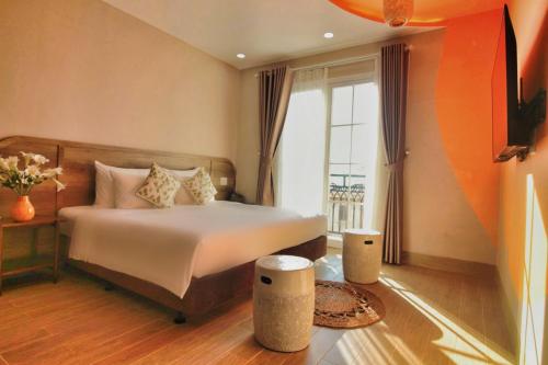 a bedroom with a bed and a large window at Aurora Phu Quoc Hotel & Cafe in Phú Quốc