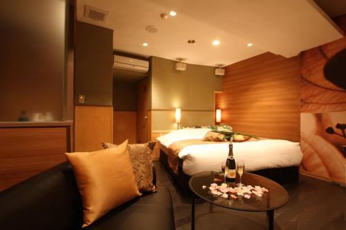 a hotel room with a bed and a couch at ホテルミュゼ愛子Hotel MUSEE Ayashi in Sendai