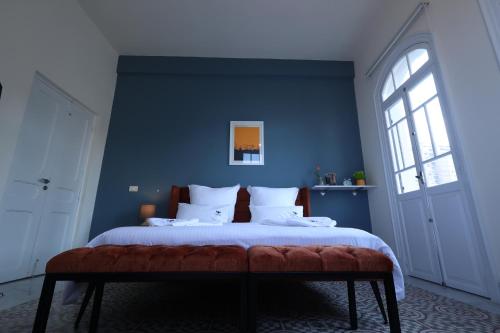 a bedroom with a large bed with a blue wall at THE GEM BOUTIQUE HOTEL in Beirut
