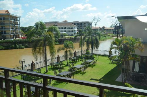 a park with tables and chairs next to a river at Saksiri Riverside Boutique Hotel in Vang Vieng