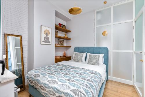 Schlafzimmer mit einem Bett mit blauem Kopfteil in der Unterkunft HCG Art'Muse Apartment in Batumi