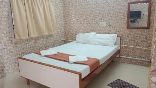 ein kleines Schlafzimmer mit einem Bett und einem Spiegel in der Unterkunft CATCH A WAVE BUDGET STAY in Mahabalipuram