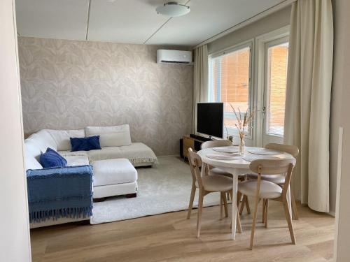 uma sala de estar com uma mesa e uma cama em Upea saunallinen kaksio Sibeliustalon vieressä em Lahti