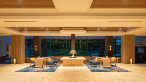 een lobby met stoelen en een tafel in een gebouw bij EN RESORT Grandeco Hotel in Kitashiobara