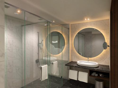 a bathroom with two sinks and a glass shower at WOW Crest, Indore - IHCL SeleQtions in Indore
