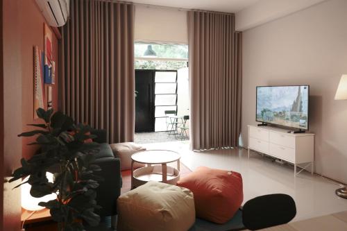 a living room with a couch and a tv at 4 bedrooms, Private & Cozy house @ Walking Street in Chiang Rai