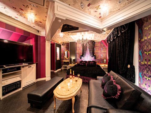 a large living room with a couch and a tv at Roselips Tsuruhashi ローズリップス鶴橋adult only in Osaka
