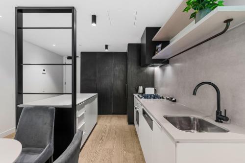 een keuken met een wastafel en een aanrecht bij The Eminence Apartments by CLLIX in Melbourne