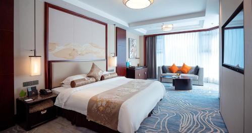 a hotel room with a large bed and a television at Yancheng Shuicheng Hotel in Yancheng