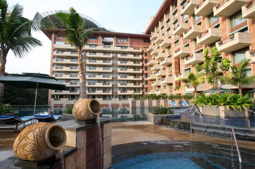 a hotel with a swimming pool in front of a building at ITC Gardenia, a Luxury Collection Hotel, Bengaluru in Bengaluru