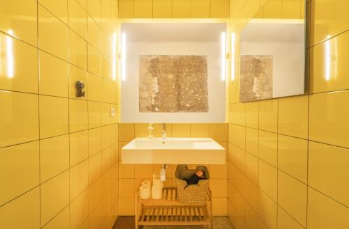un baño con lavabo y una persona sentada debajo. en Ca la Francesa, en Juncosa