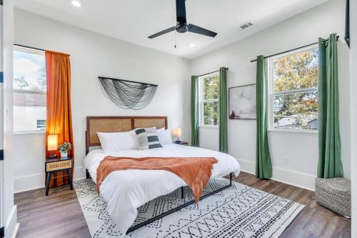 a bedroom with a bed and two windows at Modern Mid-city Maison in New Orleans