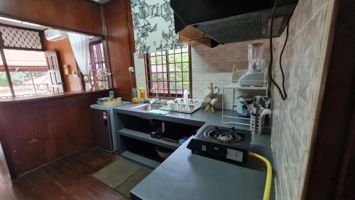 a kitchen with a sink and a counter top at Kampong Style Homestay Pengkalan Balak - Sea View in Pengkalan Balak