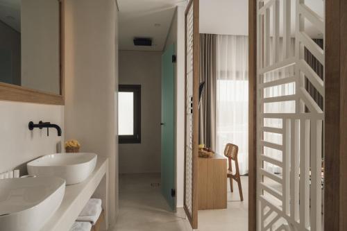 un bagno con due lavandini bianchi e una scala di Sundunes Hotel Naxos a Plaka