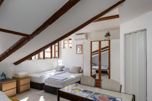 a bedroom with two beds and a table in it at B&B BUZA HOUSE in Dubrovnik