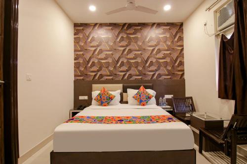 1 dormitorio con 1 cama y pared de madera en FabHotel Rosewood Inn en Amritsar