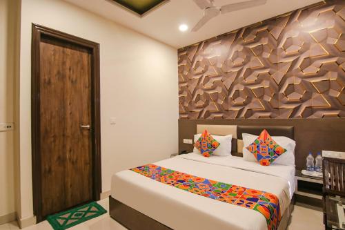 1 dormitorio con 1 cama y pared de madera en FabHotel Rosewood Inn en Amritsar