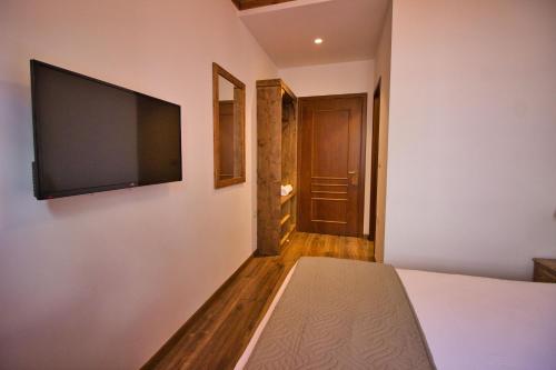 a bedroom with a flat screen tv on the wall at 4 Rooms Gjirokastra in Gjirokastër