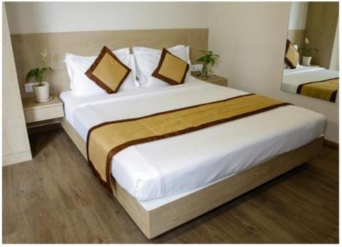 1 dormitorio con 1 cama blanca grande y 2 almohadas en TRANSTREE at Brookfields en Bangalore