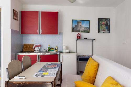cocina con armarios rojos y mesa en la cocina en B&B BUZA HOUSE, en Dubrovnik