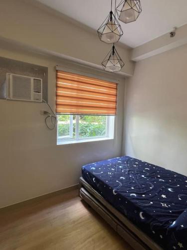 Tempat tidur dalam kamar di Trees Residences Staycation Fairview QC