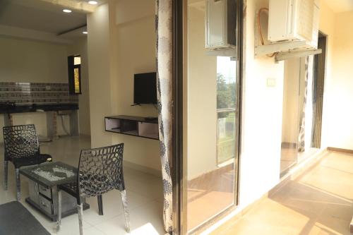 a room with two chairs and a table and a television at The Retreat by City Homes Aashiyaanaa in Jambhulpāda