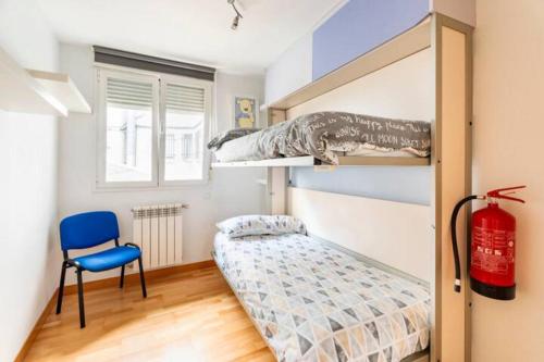 - une chambre avec des lits superposés et une chaise bleue dans l'établissement MUI Pamplona, à Pampelune