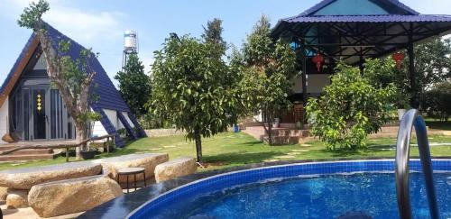 una piscina en un patio con una casa en Mộc Hoa Viên, en Ấp Thiện Lập