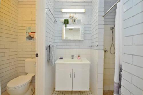 a white bathroom with a toilet and a sink at Central 2Bed 2Storey Pool-Skywalk Kalbarri in Kalbarri