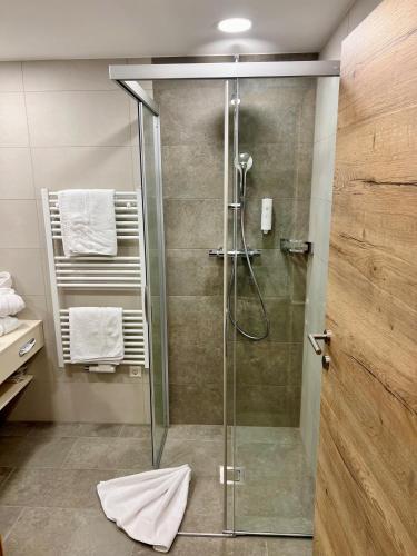 a shower with a glass door in a bathroom at Andi's Skihotel in Obertauern
